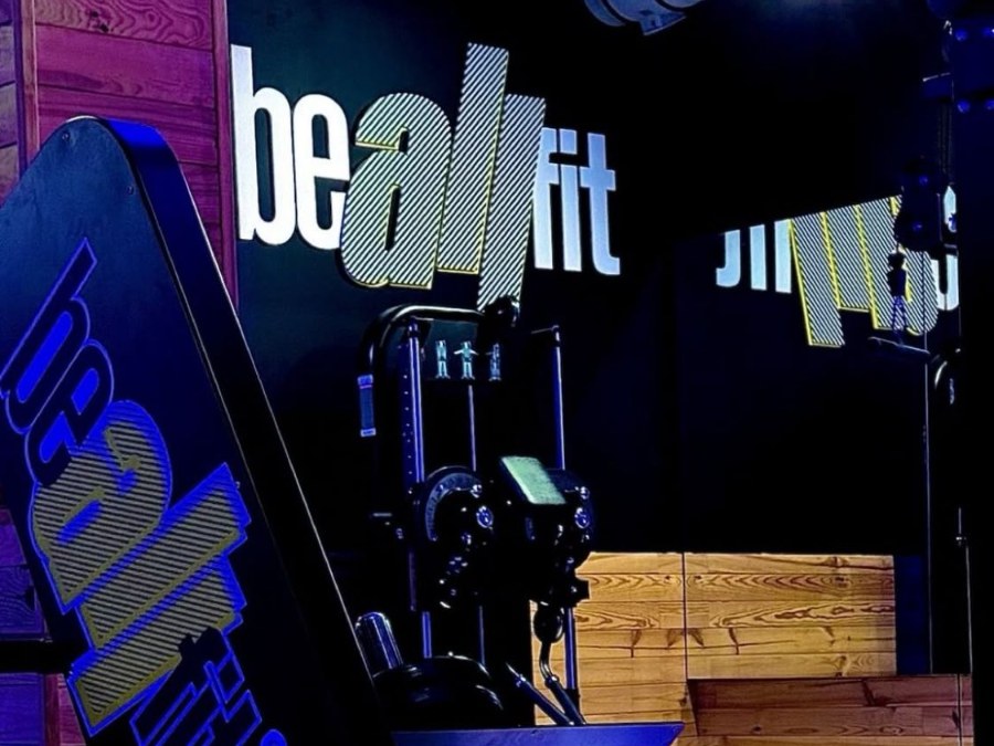 Máquina de prensa y logo de Beallfit en la zona de piernas